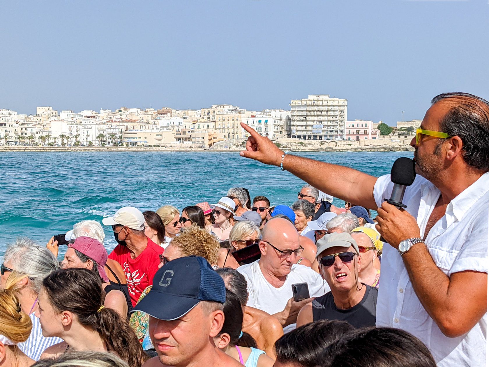 animatore mentre spiega informazioni sul tour alle grotte marine dalle motobarche Leonarda di Vieste nel Gargano